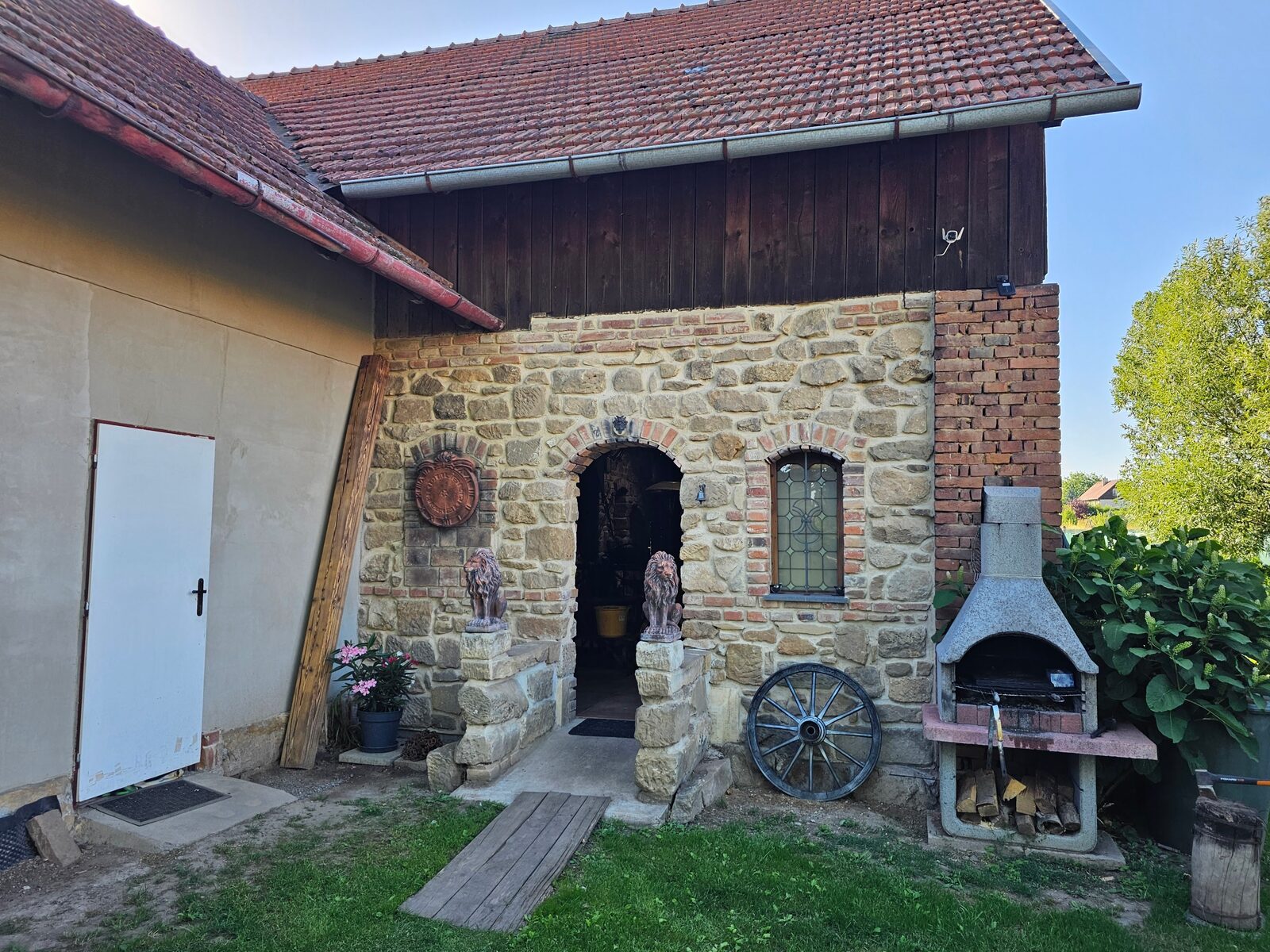 Kamenný vchod do Templářské stodoly se dvěma sochami lvů a venkovním grilem