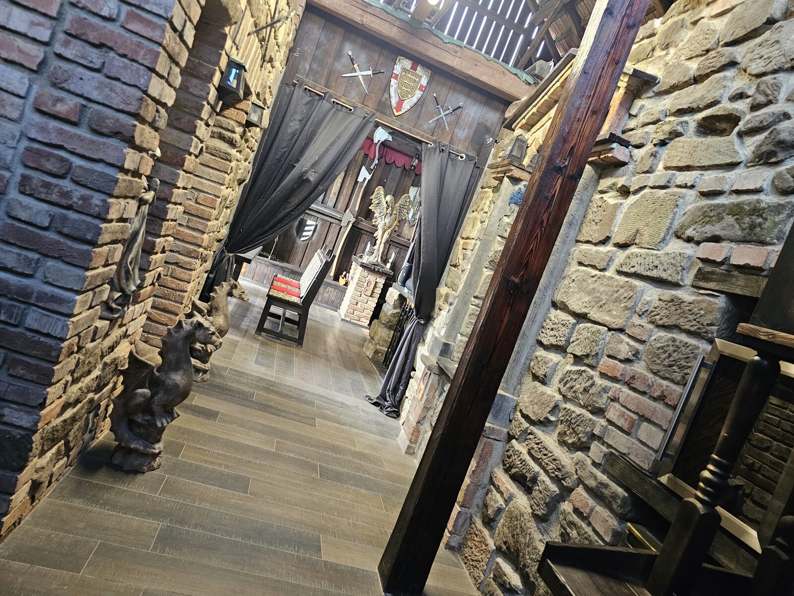 Kamenná chodba s chrliči, závěsy a rytířským štítem